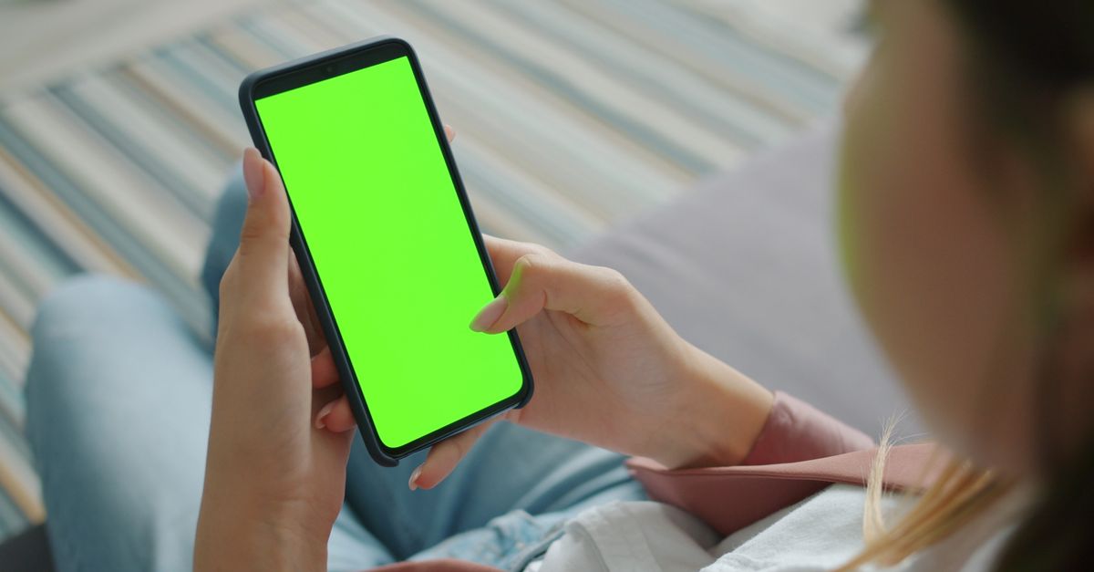 Persona sosteniendo un teléfono inteligente con la pantalla encendida