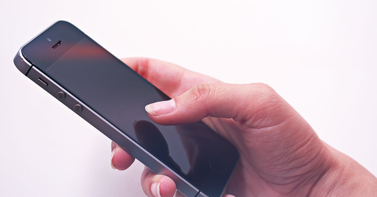 Persona sosteniendo un teléfono inteligente con la pantalla encendida