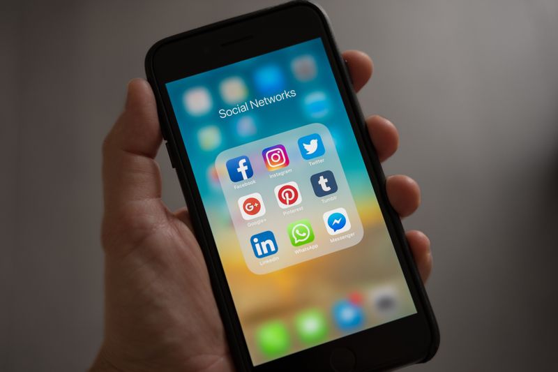 Persona sosteniendo un teléfono inteligente con la pantalla encendida
